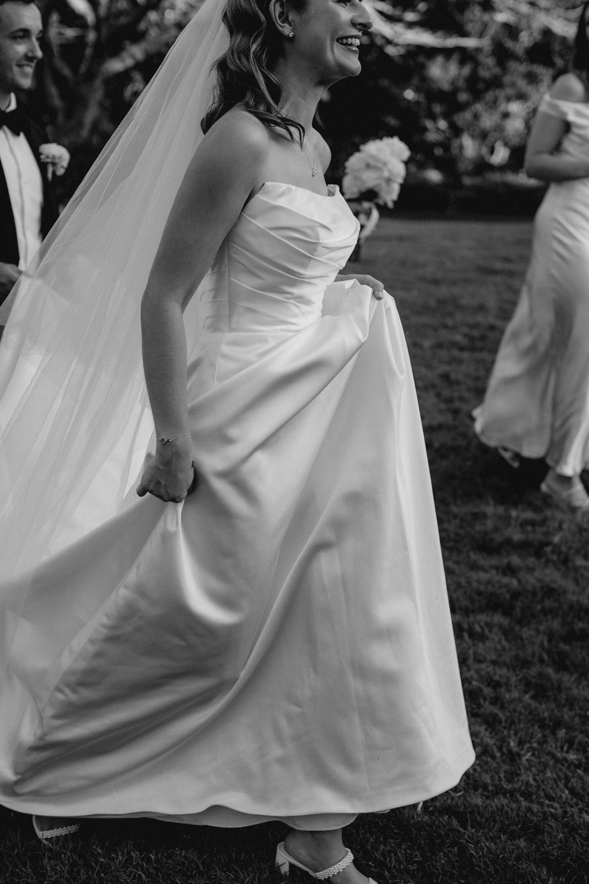 Bridal alterations experts of a bride in a wedding dress with a flowing train.